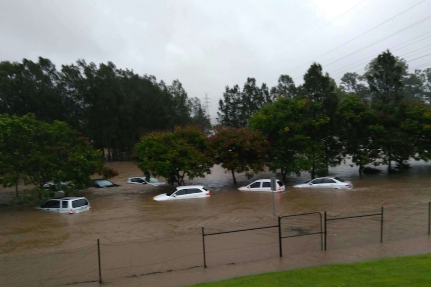 Cars are submerged in floodwaters outside Robina Hospital