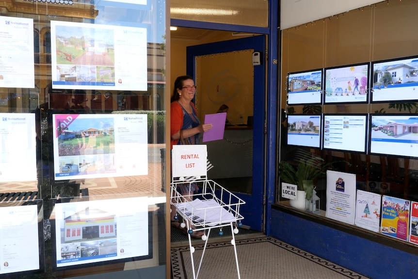 A woman walking out of a real estate office