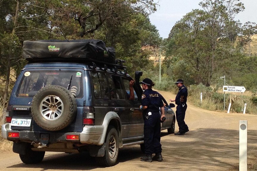 Tasmania Police turn back cars near a fire in Tasmania's south-east, January 28 2014.