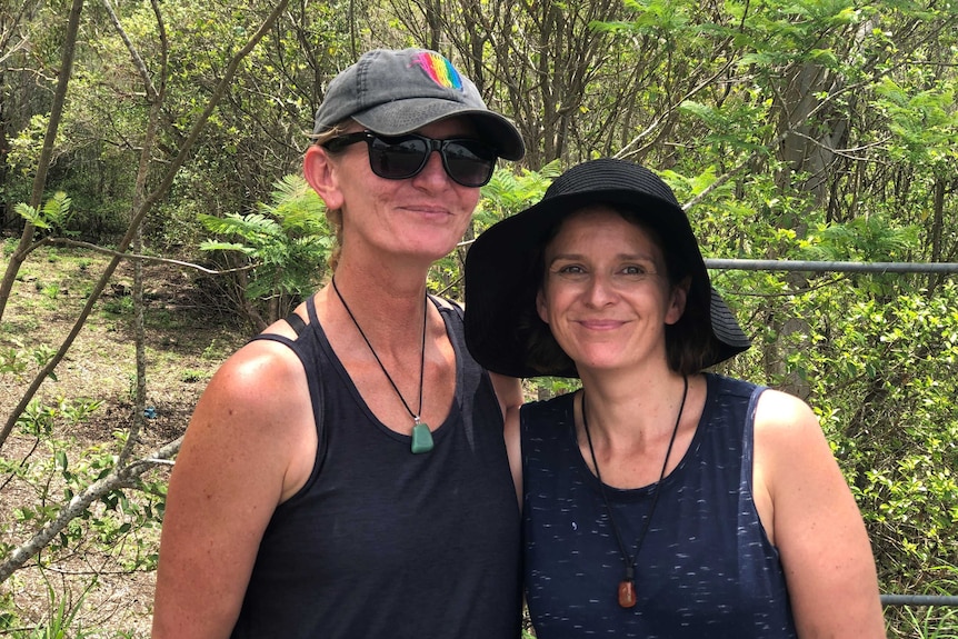 Two women in hiking clothing standing in bushland.