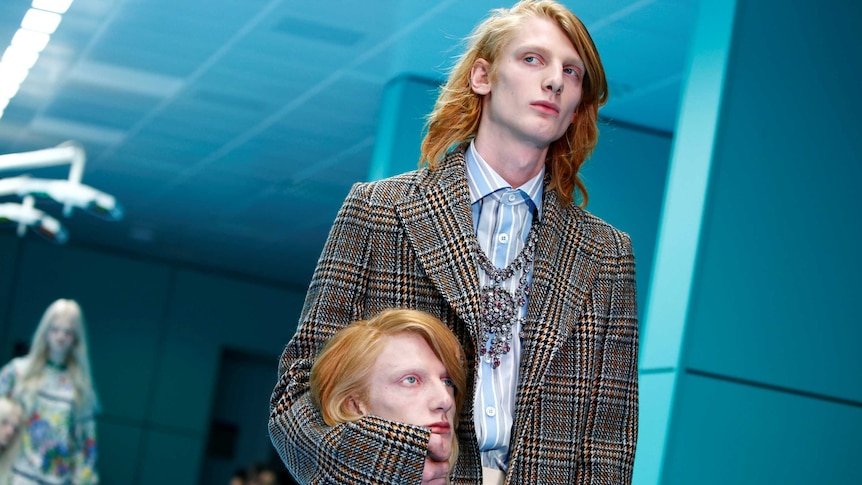 Model with fake head of himself parades during Milan Fashion Week