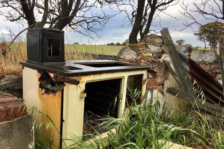 An old stove stands amongst rubble