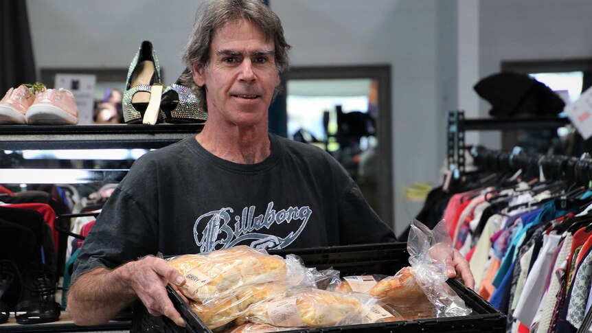 Stephen Reynolds holds a large tray of bread rolls.