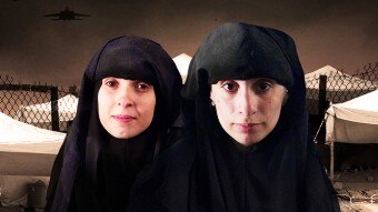 Two women wearing black head-covering garments look directly into the camera.