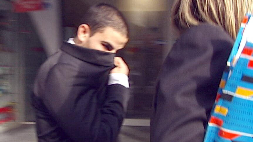 Hassan El Sabsabi covers his face with his suit jacket as he leaves Melbourne Magistrates Court.