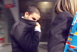 Hassan El Sabsabi covers his face with his suit jacket as he leaves Melbourne Magistrates Court.