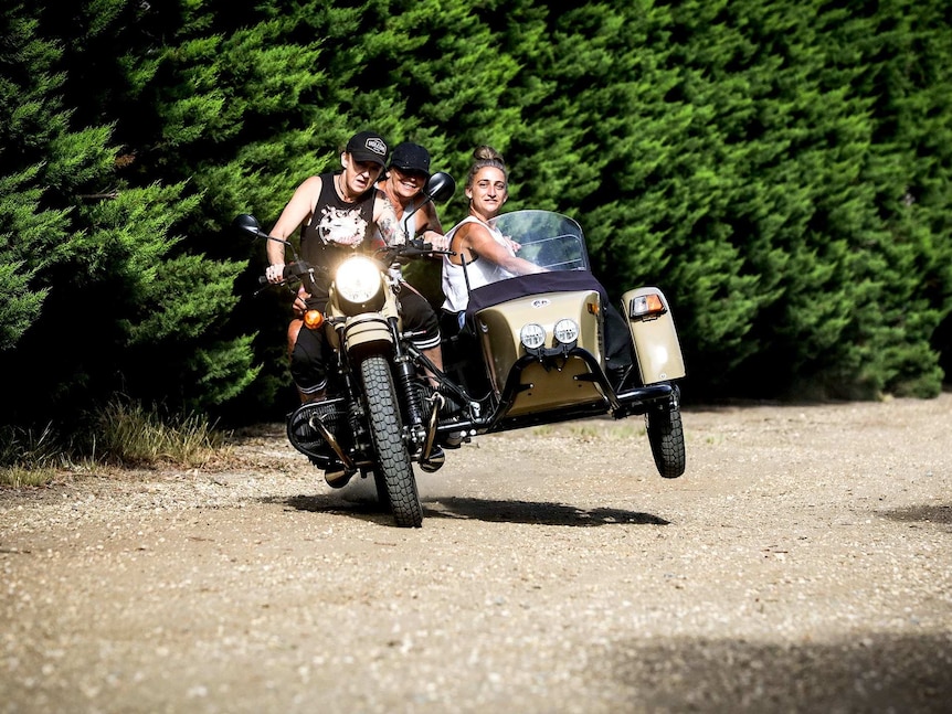 Three women in a motorbike with vintage sidecar