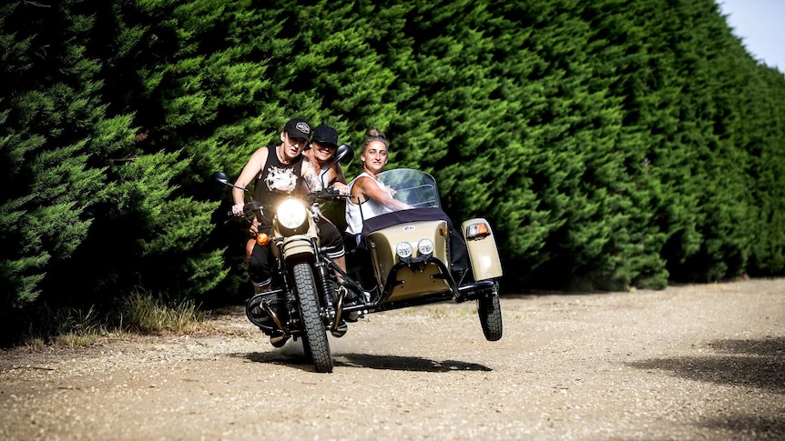 Three women in a motorbike with vintage sidecar