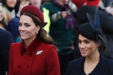 Kate Middleton, left, enters church wearing a matching red coat and hat along with Meghan Markle, wearing a navy coat and hat.