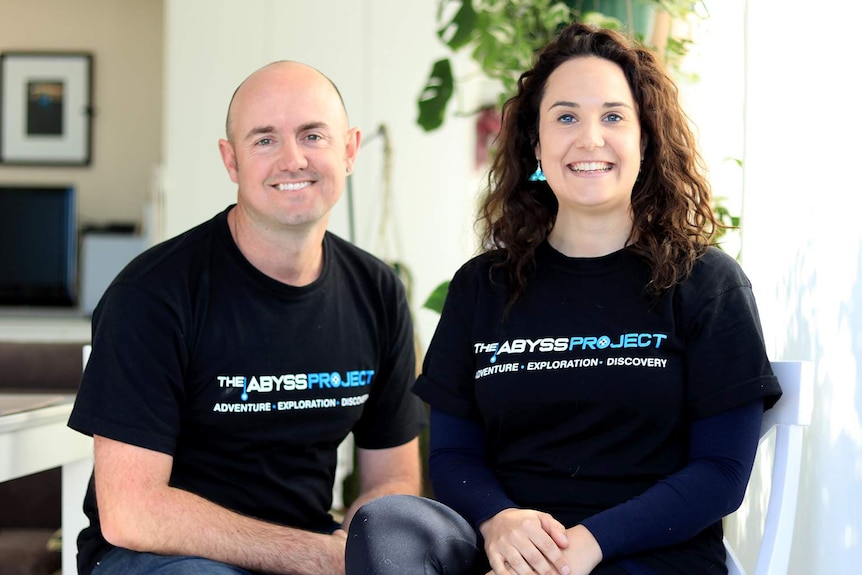 Carl Fallon and Nathalie Simmonds from The Abyss Project sit inside a house with plants in the background.