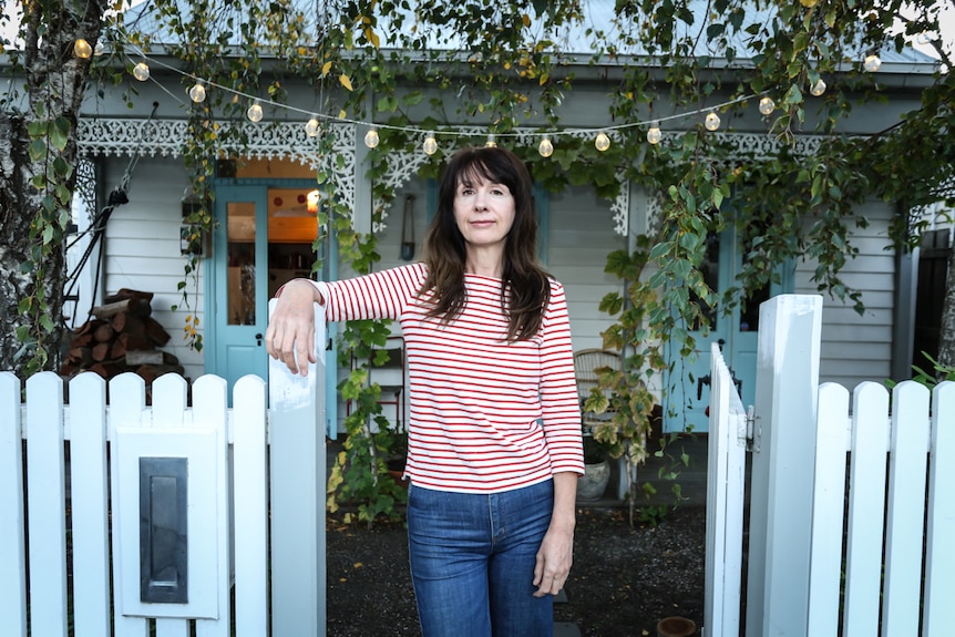 A woman with dark hair stands outside a house in inner-city Melbourne