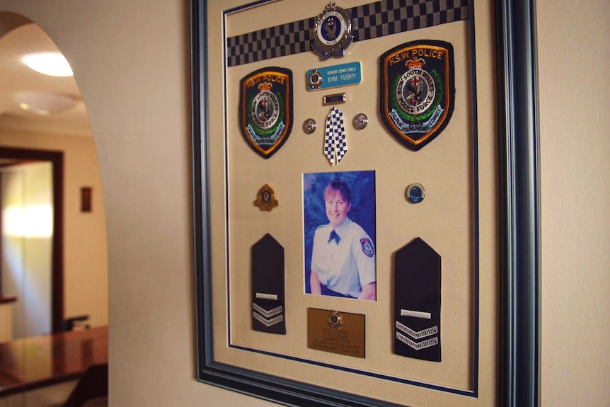 A photo and medals displayed on the wall of a room.