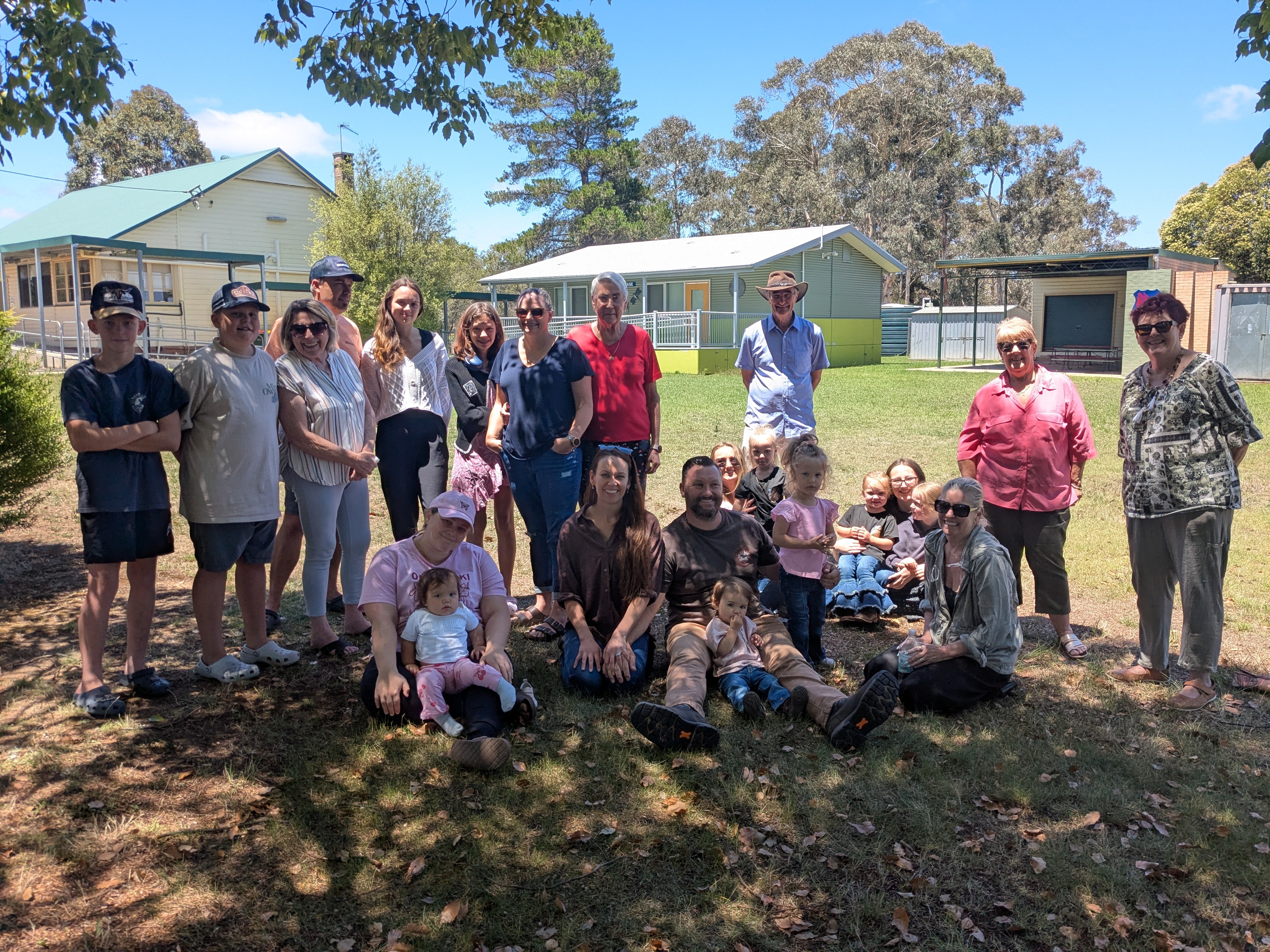 Un grupo de personas está de pie en el patio de una escuela.