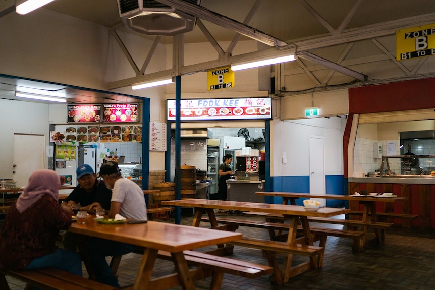 People gather and eat in a hawkers style food hall