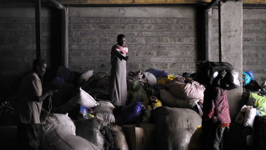 Warehouse attendants carry bags of goods donated during a funds drive by the Somali community living in Kenya's capital, Nairobi