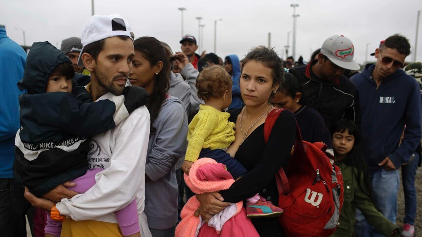 Venezuelan families wait for breakfast after crossing border into Peru.