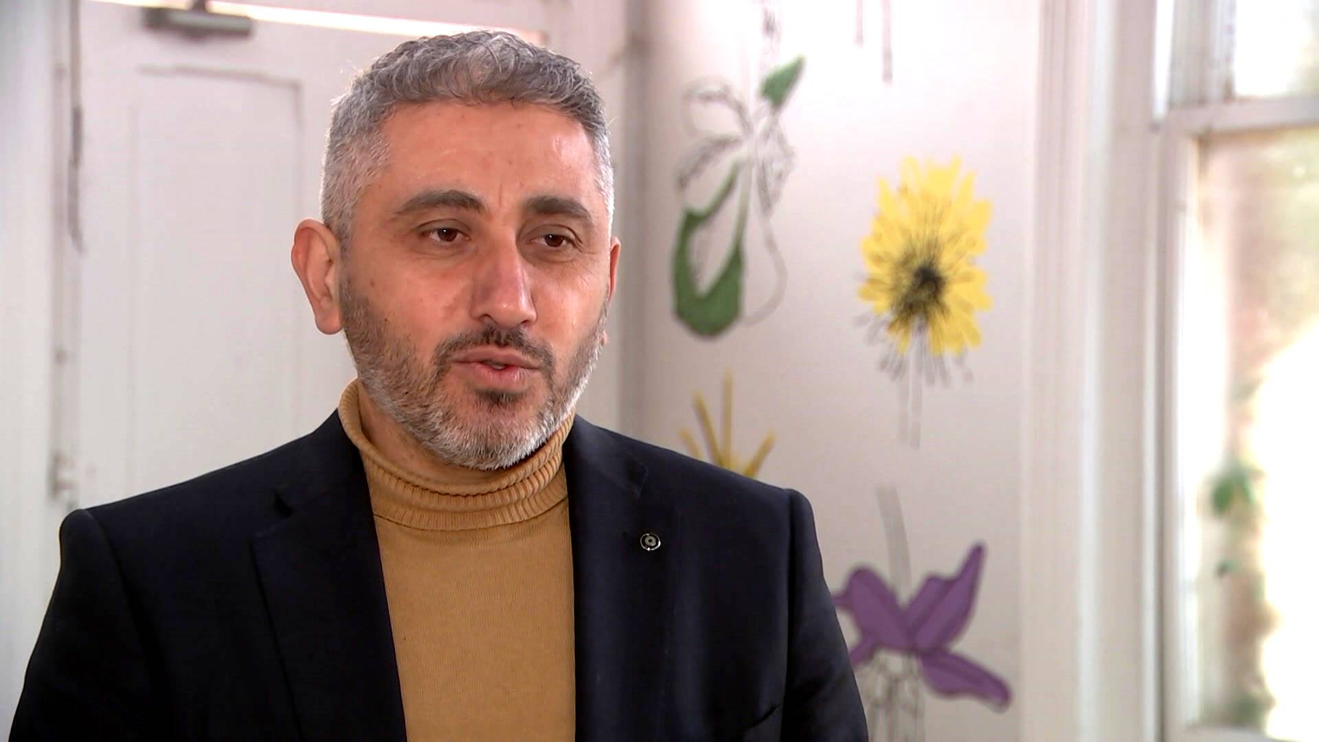 A man with a beard and wearing a suit jacket.