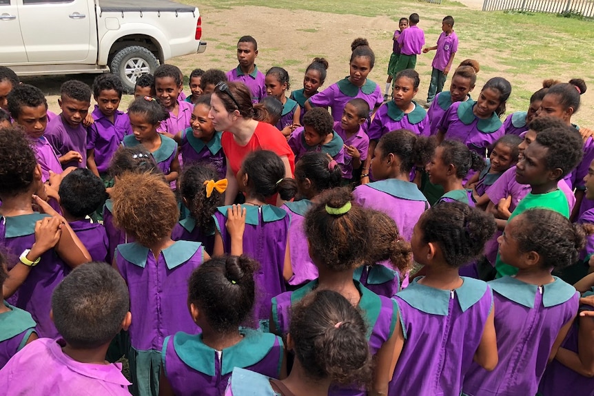 Mrs McDonald is surrounded by school children in PNG.