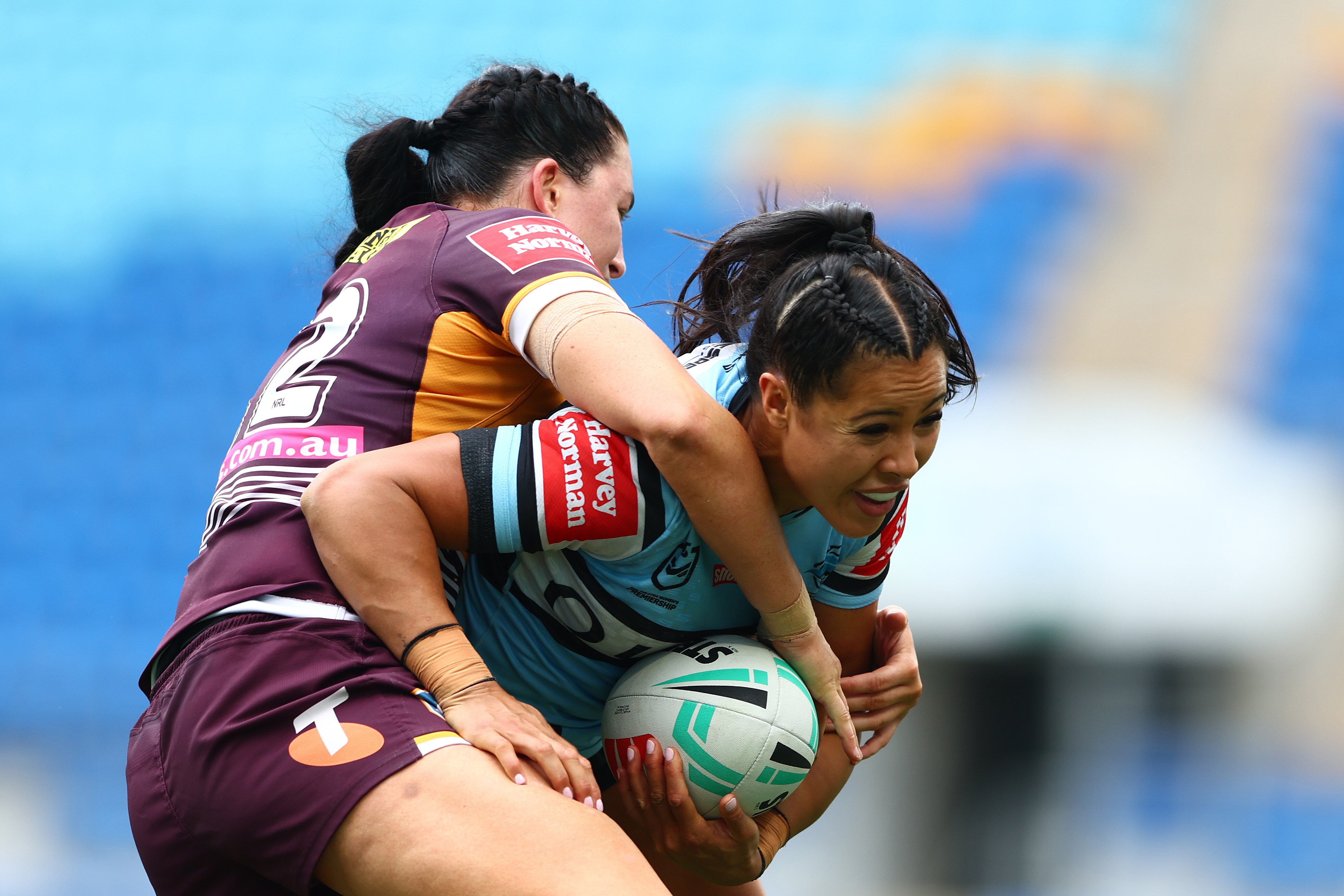 A woman runs the ball during a rugby league match 