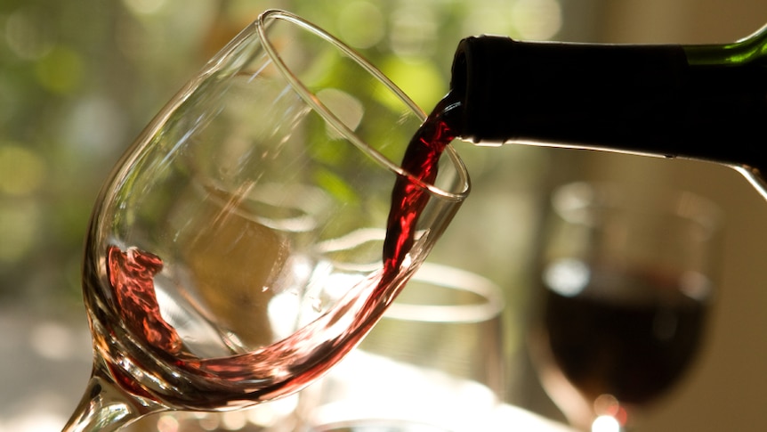 A close-up of wine being poured from a bottle into a glass