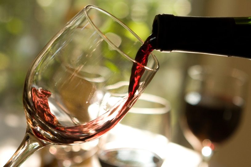 A close-up of wine being poured from a bottle into a glass