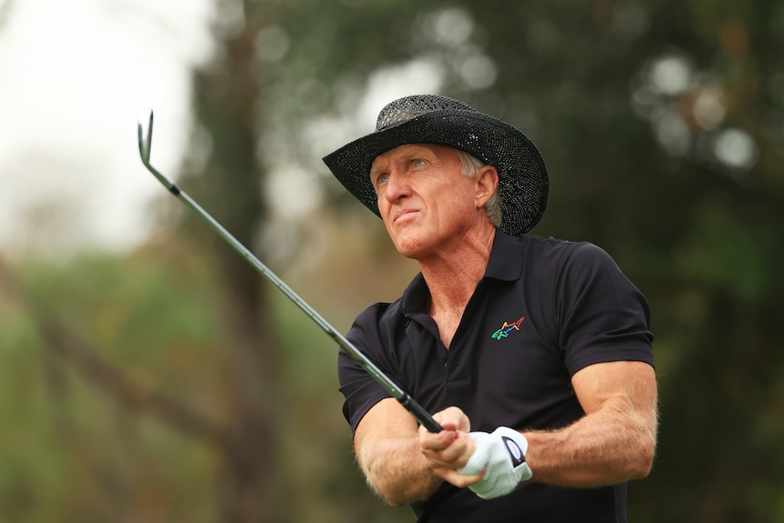 Greg Norman looks on after completing a shot