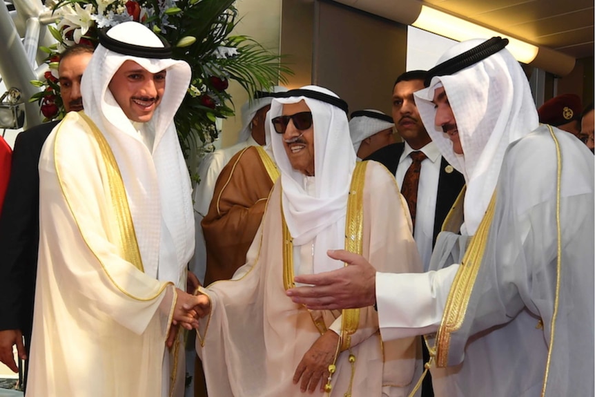 Three men in Arab dress meet, Kuwait Sheikh Sabah al-Ahmad al-Sabah is in the middle wearing sunglasses.