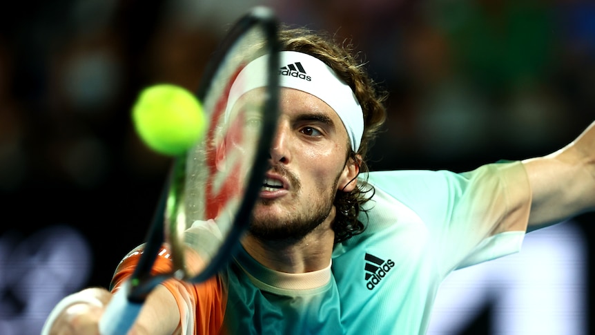 A Greek tennis male tennis player hits a backhand at the Australian Open.