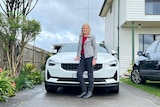 Wendy Farmer stands in front of her electric vehicle which is parked in her driveway in Gippsland. 
