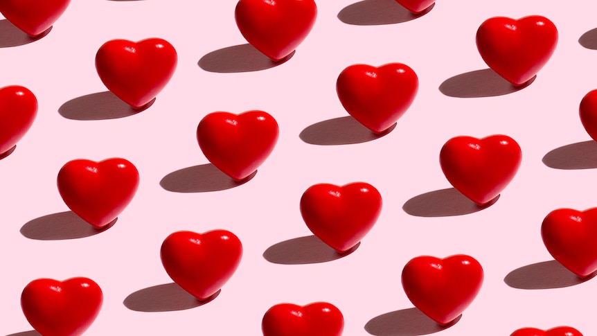 pattern of cartoon red hearts against pink background