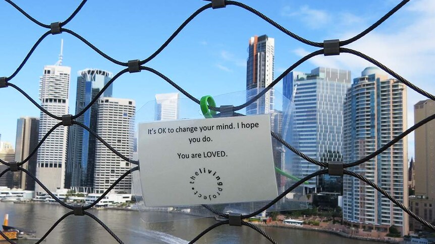 Laminated sign 'OK to change your mind, , I hope you do - You are LOVED' zip-tied on a bridge.