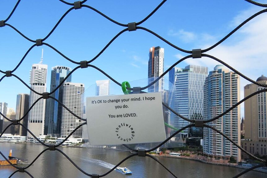 Laminated sign 'OK to change your mind, , I hope you do - You are LOVED' zip-tied on a bridge.