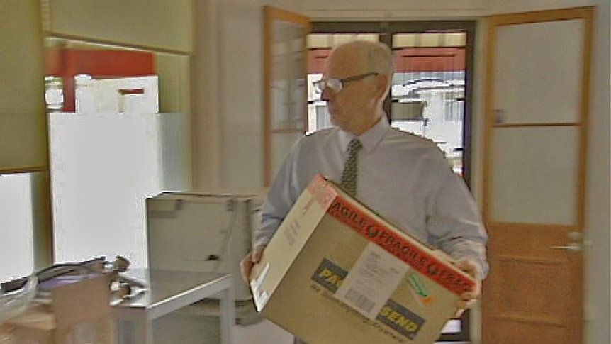 Euthanasia campaigner Philip Nitschke carrying a box at Adelaide clinic