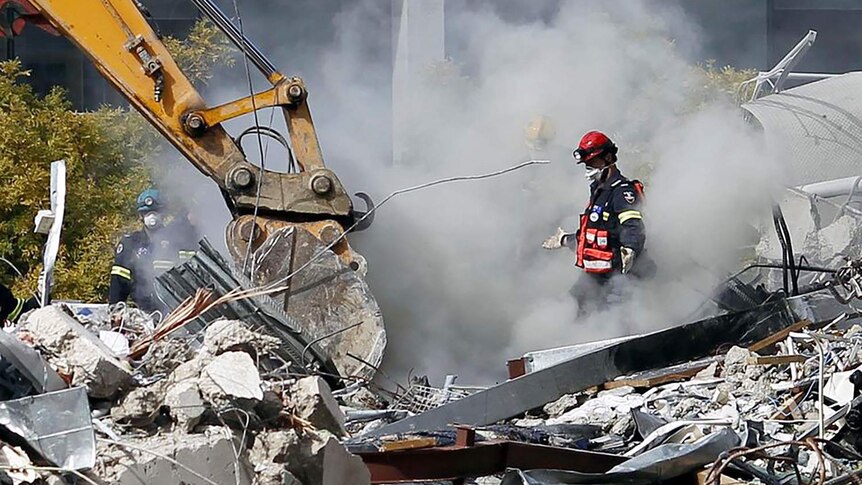 Rescue workers search for signs of life in the rubble of CTV building after an earthquake in Christchurch