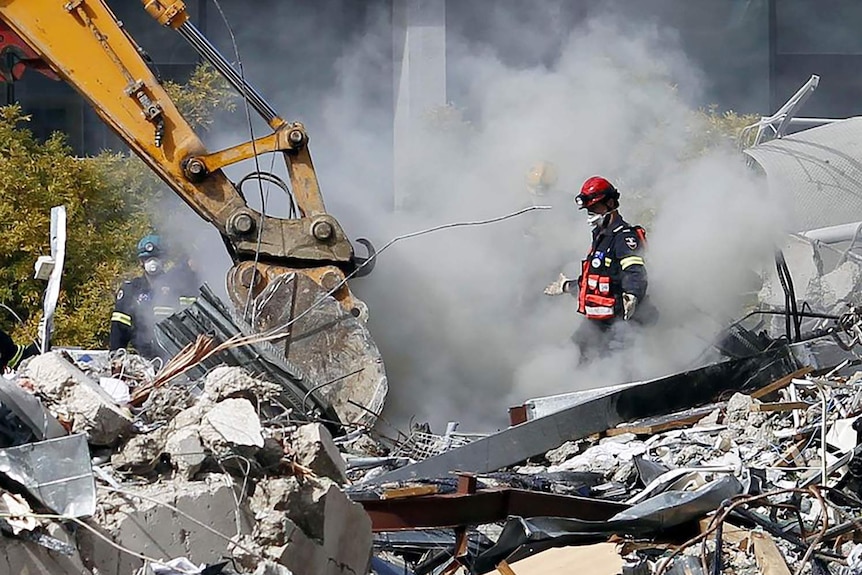 Rescue workers search for signs of life in the rubble of CTV building after an earthquake in Christchurch