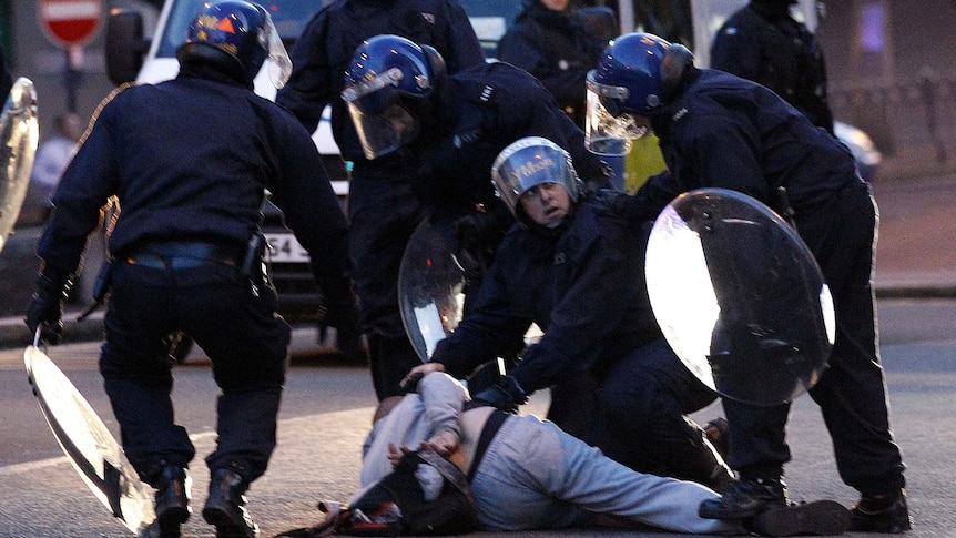 Police detain a man in central Birmingham.