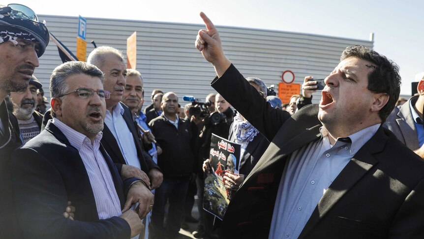 The head of Israel's Arab parliamentary bloc, Ayman Odeh, leads a demonstration in front of the Knesset.
