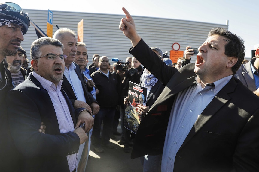 The head of Israel's Arab parliamentary bloc, Ayman Odeh, leads a demonstration in front of the Knesset.