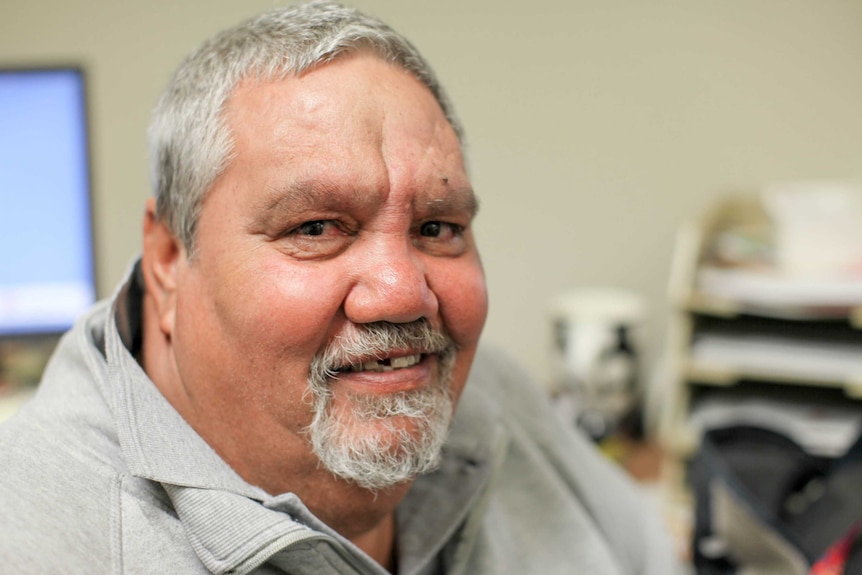 Phillip Sullivan sits in his office and smiles