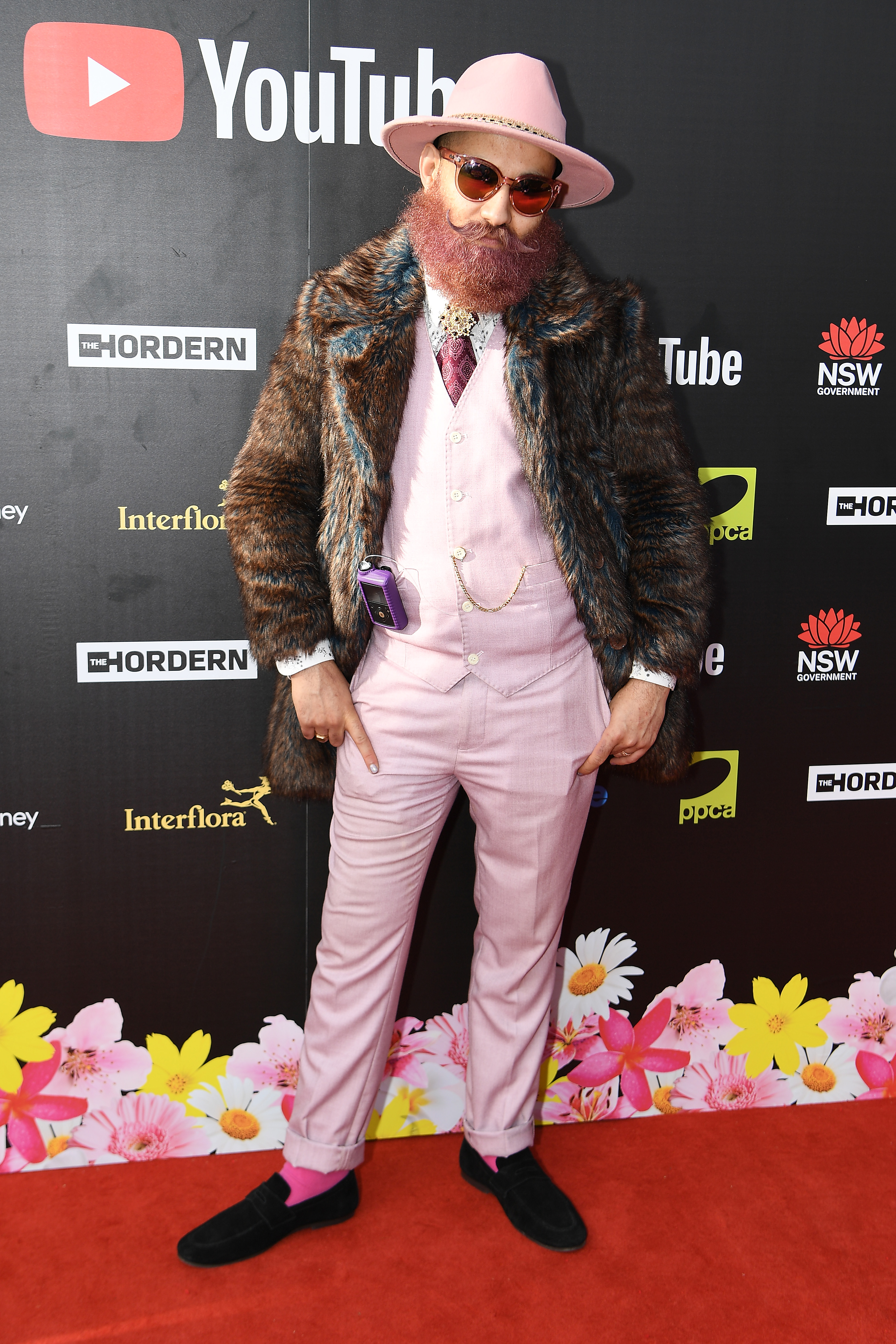 James Tawadros wearing a pale pink suit with a furry coat