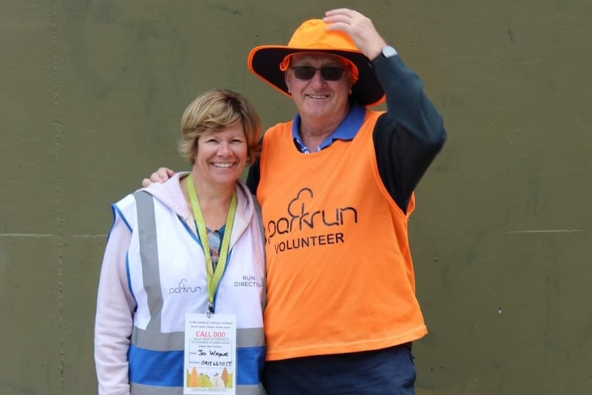 A man and a woman pose for a photo with their arms around each other.