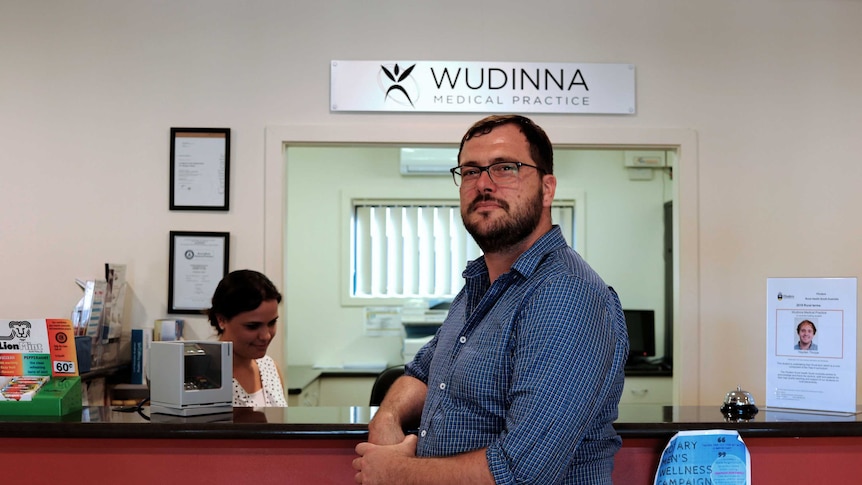 Wudinna GP Dr Scott Lewis smiles at the camera in his practice's waiting room.