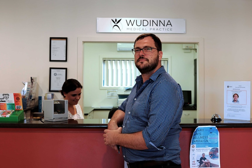 Wudinna GP Dr Scott Lewis smiles at the camera in his practice's waiting room.