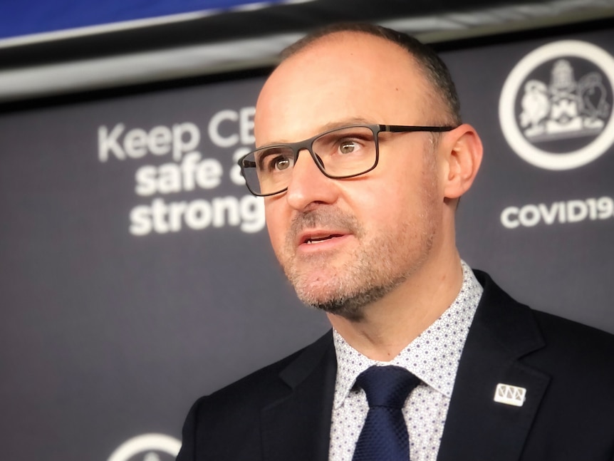 Andrew Barr looks serious while speaking at a press conference.