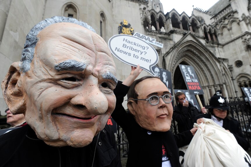 Demonstrators mock Murdochs at hacking inquiry