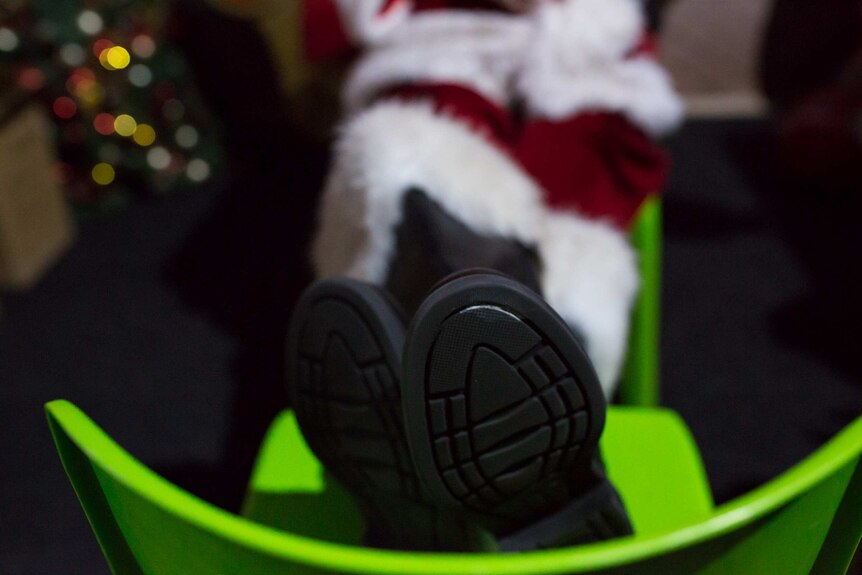 Santa's boots rest on a chair as Peter takes a break between seeing children.