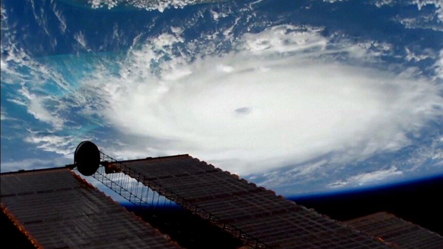Hurricane Dorian's circular cloud formation and its eye stand out clearly against the Earth's blue oceans.