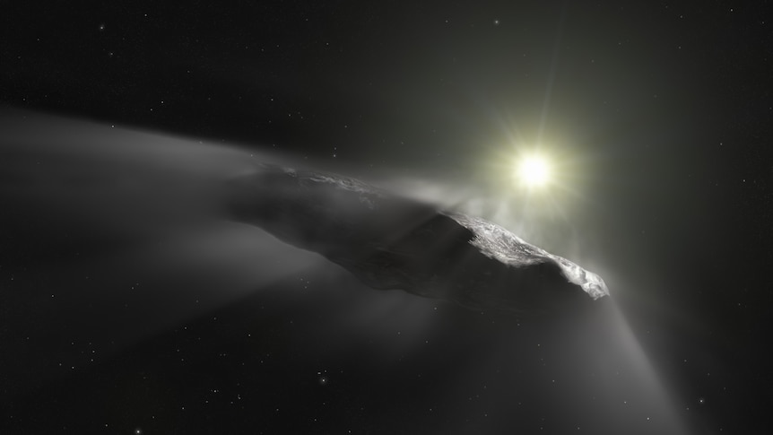 A cigar-shaped object appears in front of a bright star on a dark background somewhere in space