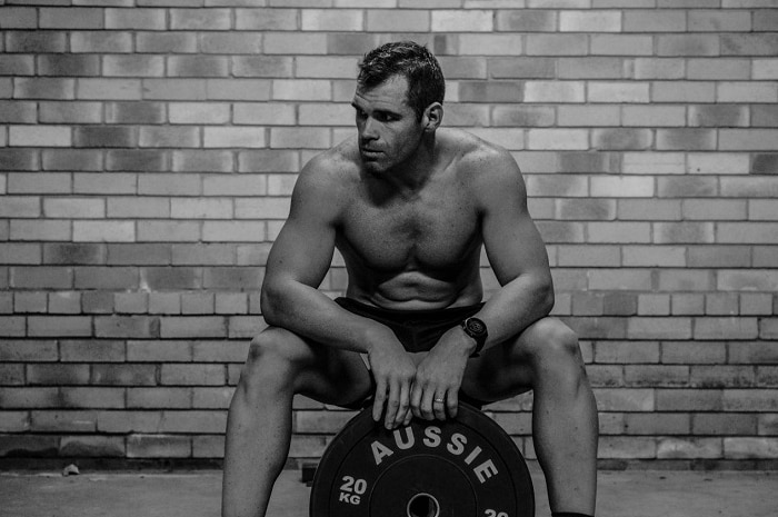 Gym owner Lachie Cameron seated with weights in the gym.
