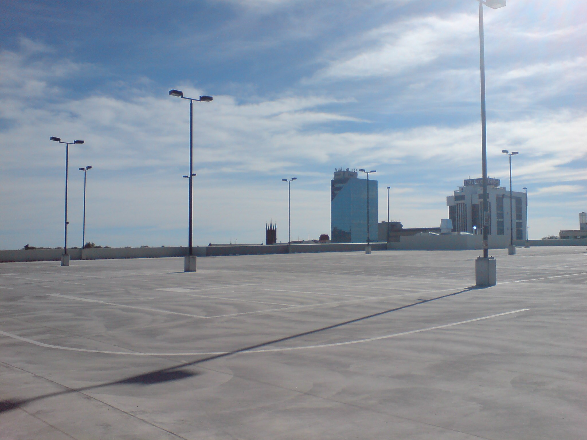 A clean, empty city parking lot with blue skies.